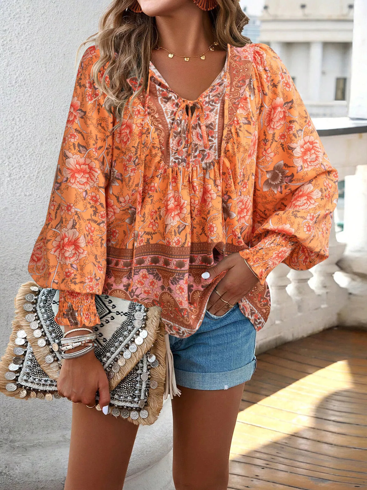 Orange floral tie-neck blouse with smocked cuffs and gathered neckline