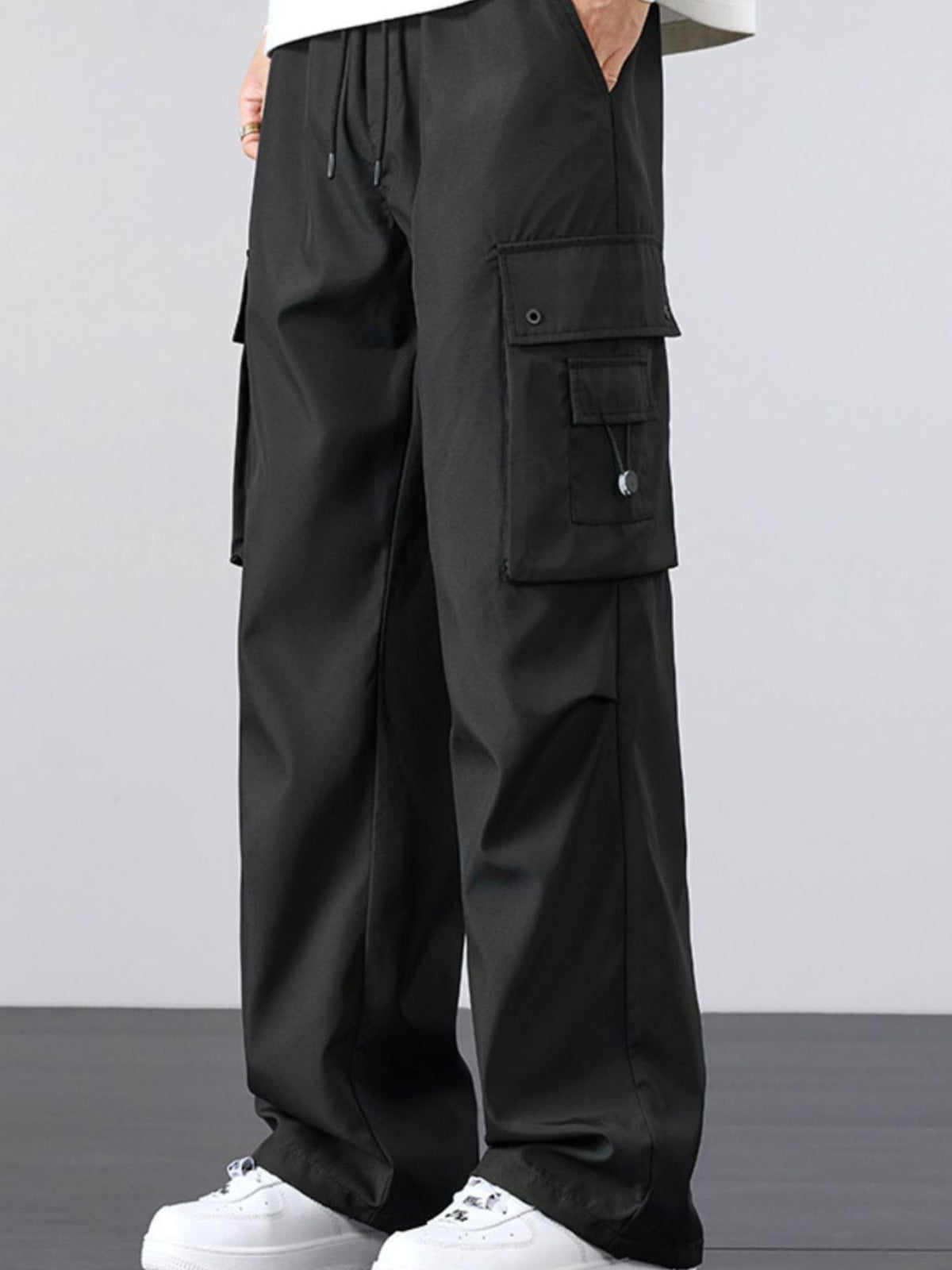 Black loose-fit cargo pants with drawstring waist and multiple side cargo pockets