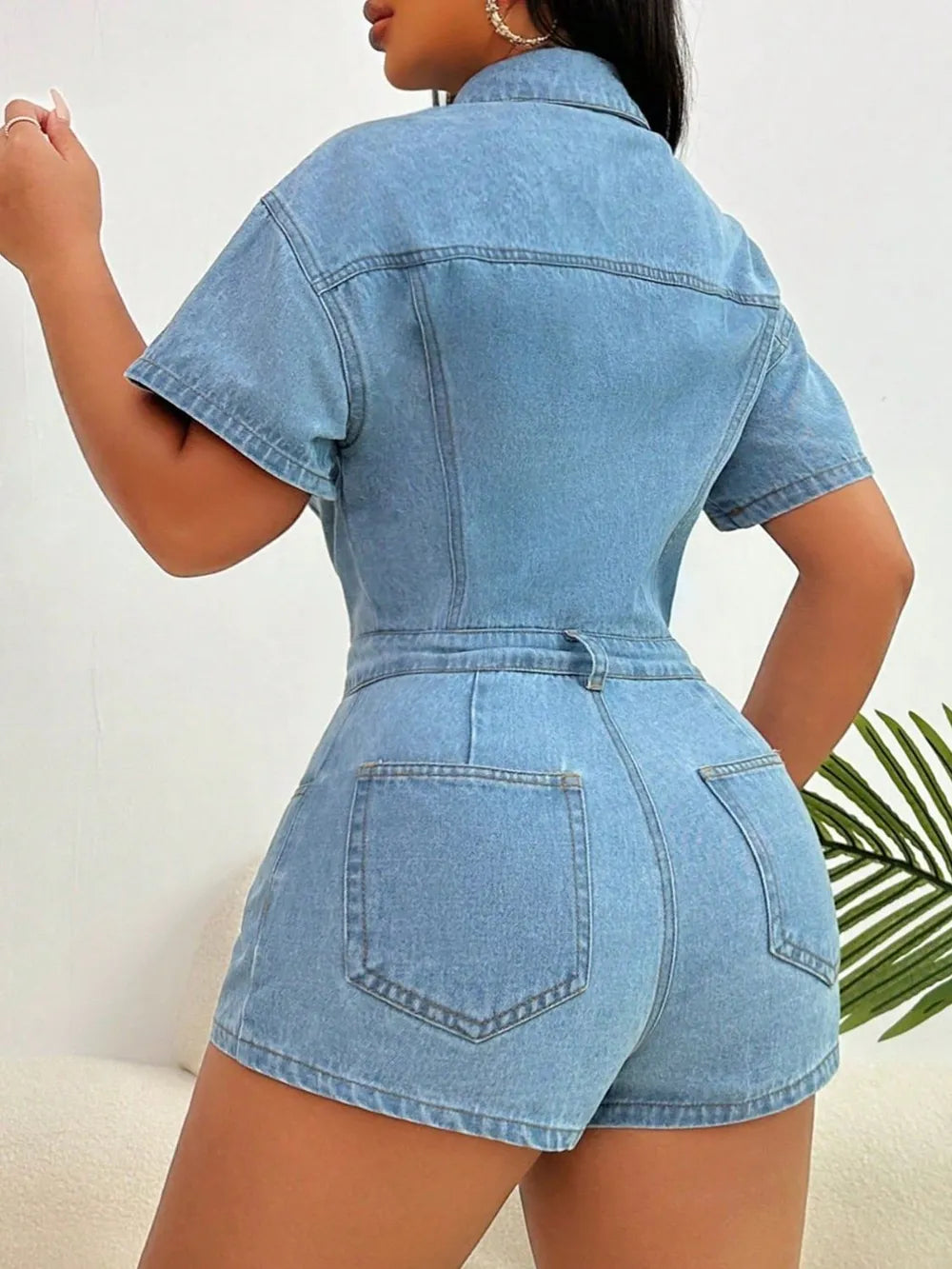 Light blue denim romper back with collared neckline, short sleeves, rear patch pocket