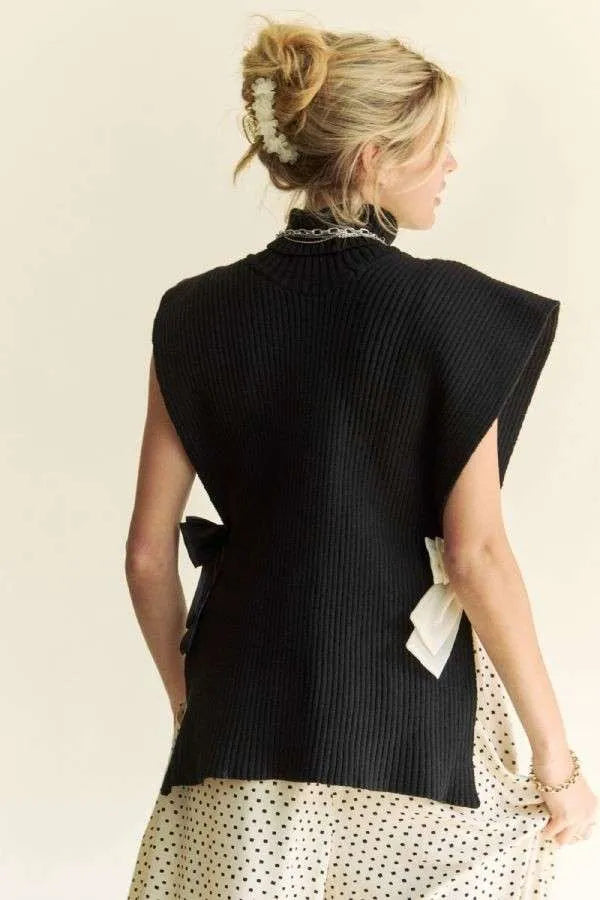 Black sleeveless rib knit turtleneck top with draped back and side slit