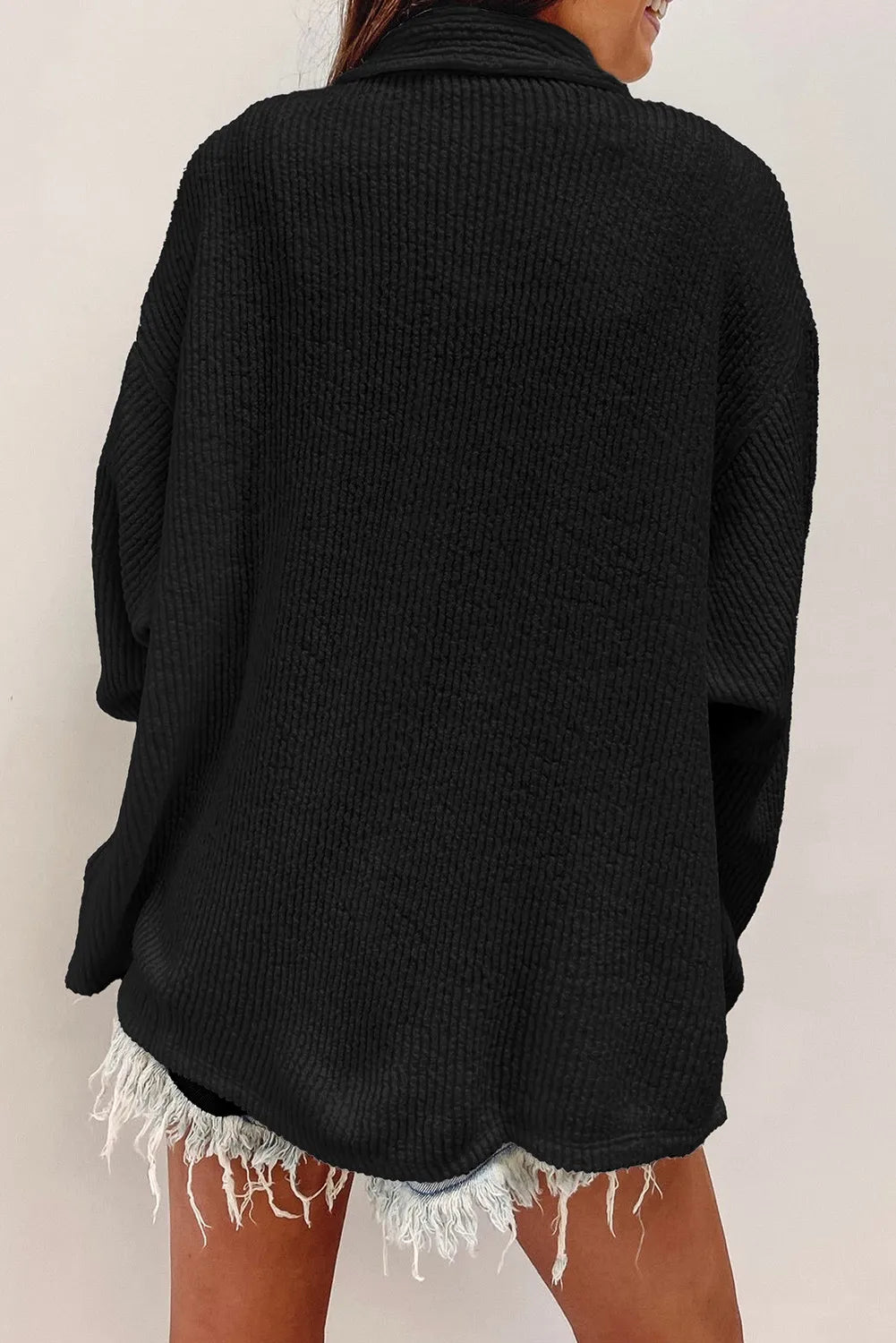 Black textured button-up long sleeve shacket from back view with yoke seam and loose fit