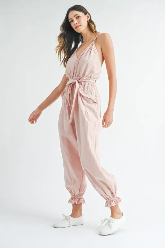 Pink spaghetti strap jumpsuit with waist tie belt and gathered ankle cuffs