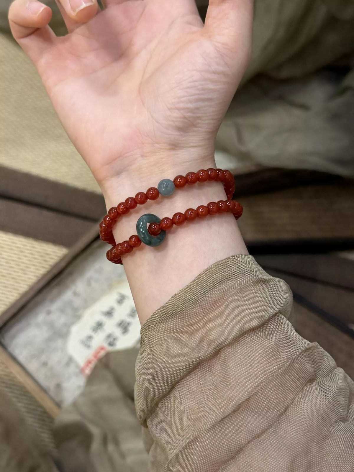 Double-layer burgundy agate bead bracelet with teal spacer bead on both strands
