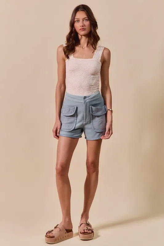 Denim blue mineral-washed terry high-rise cargo shorts worn with a white top