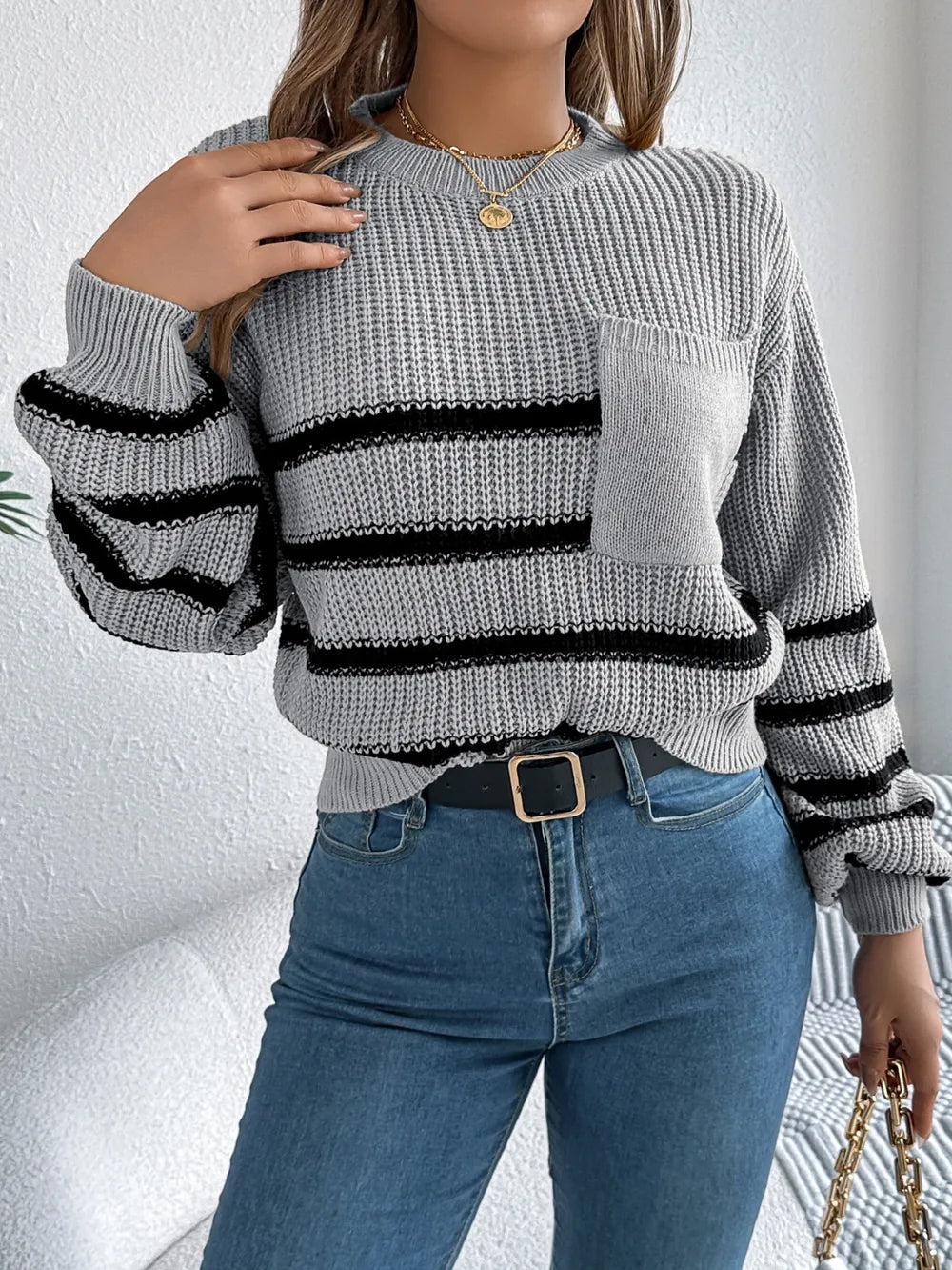 Gray striped knit sweater with round neck and long sleeves, chest pocket detail