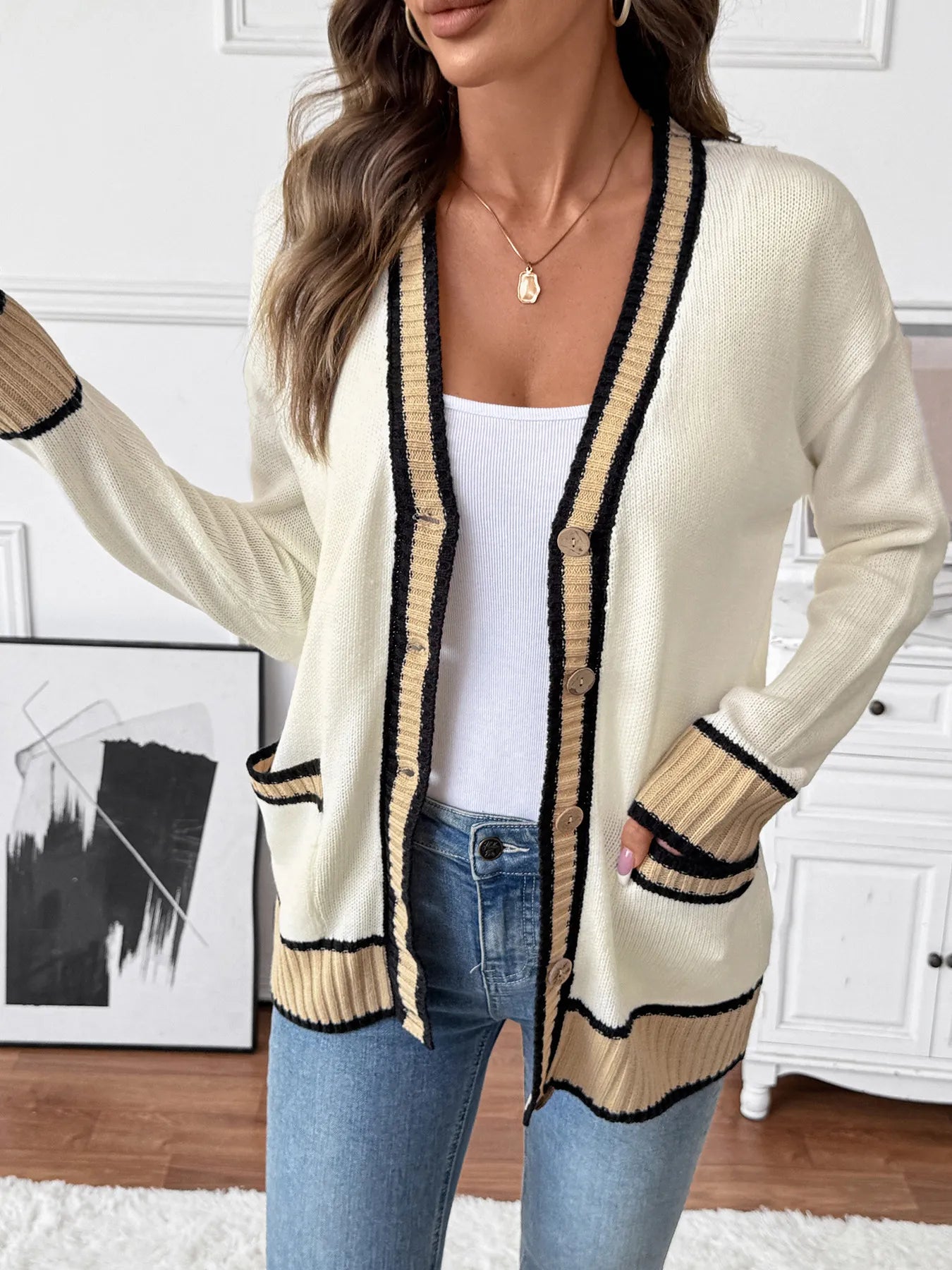 Cream knit cardigan with V-neck and black/tan contrast stripes, button front