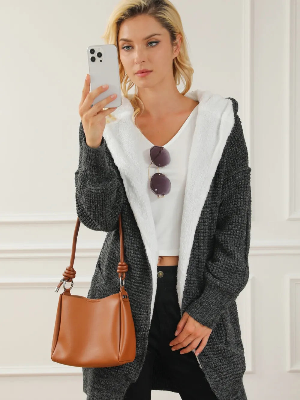 Open-front hooded winter coat with pockets, dark textured knit with hood lining and hem tie.