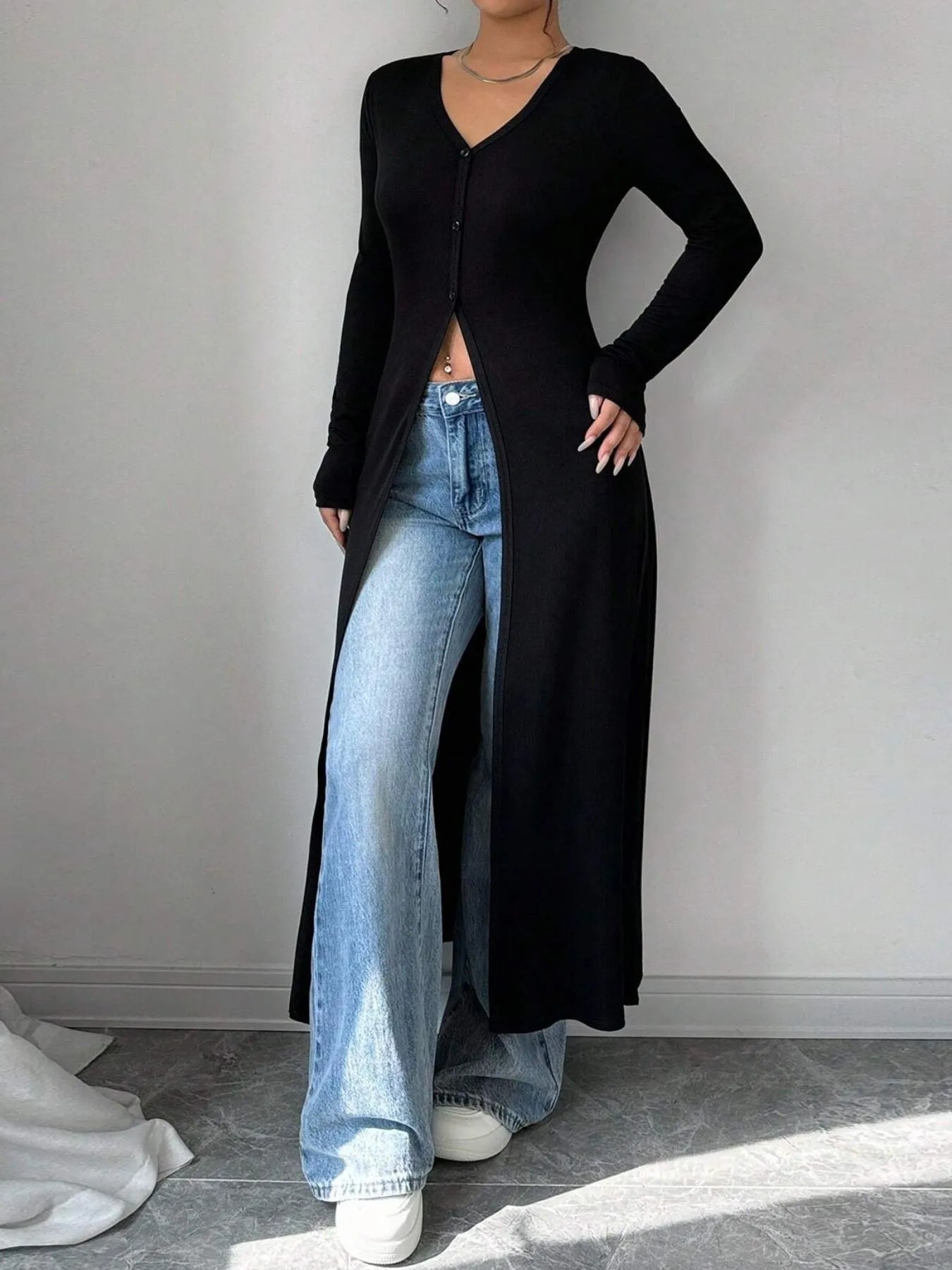 Longline V-neck button-front cardigan in black with long sleeves and side opening