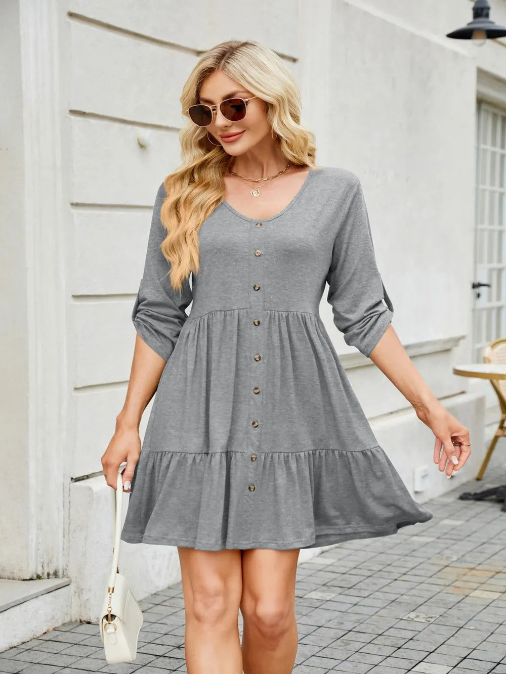 Tiered ruched V-neck mini dress by Trendsi in gray with button-front; model wears sunglasses