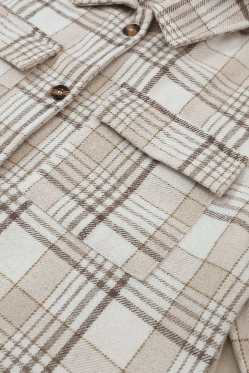 Close-up of plaid shacket fabric with brown buttons and button placket detail