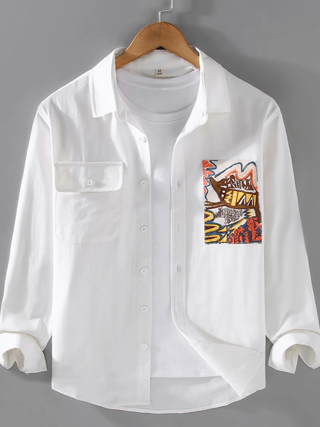 White button-up long sleeve shirt with chest pocket, front buttons, graphic patch on chest