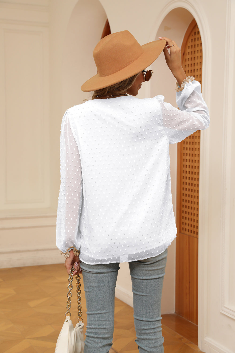 White Swiss-dot V-neck blouse with contrast trim, long sleeves (back view)