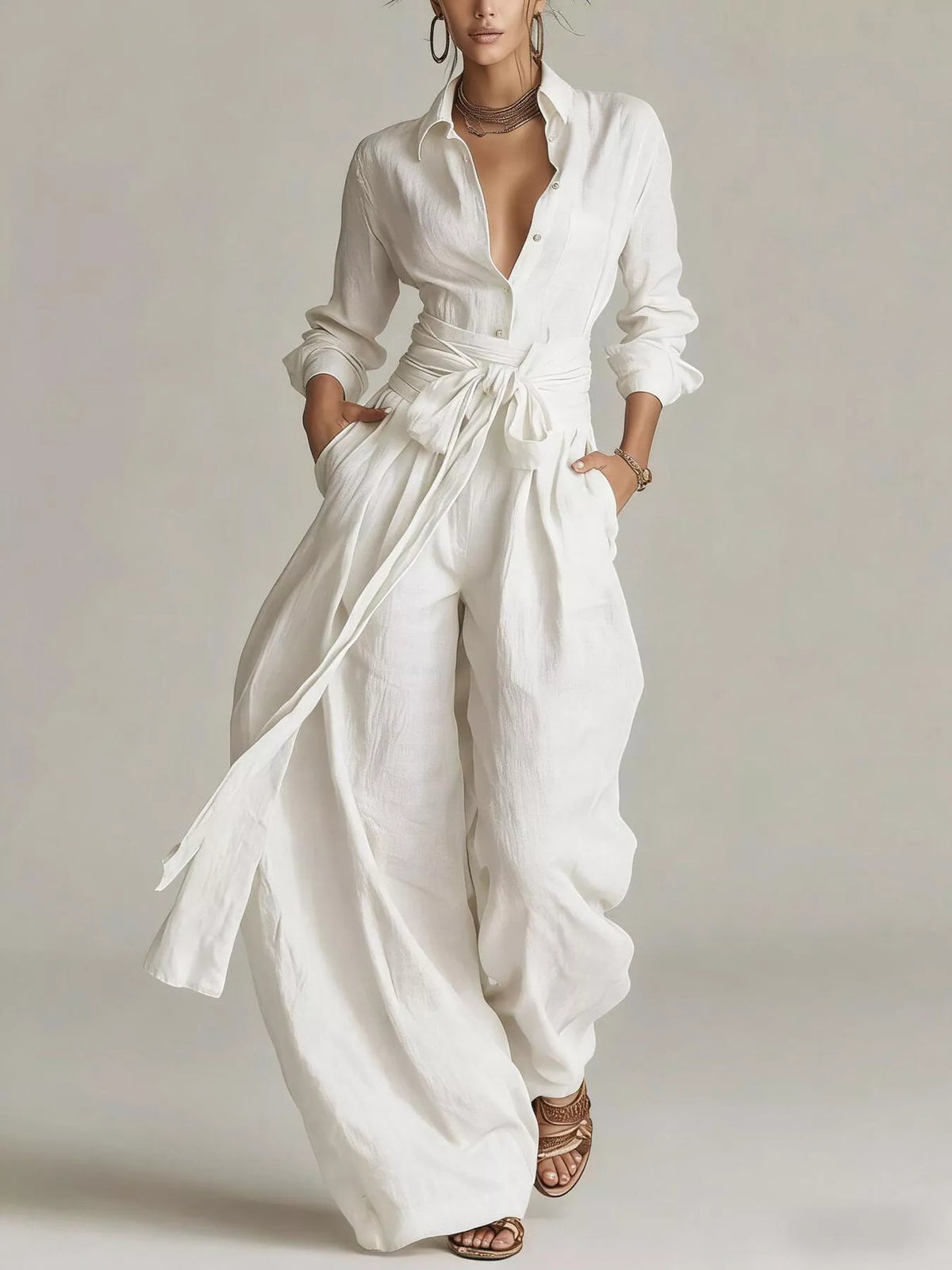 White long-sleeve button-down waist-tie jumpsuit with open collar and wide legs