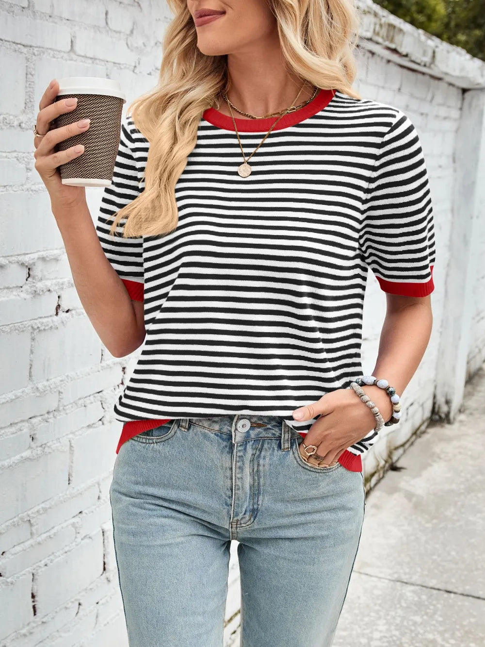 Black-and-white striped knit top with red contrast crew neck and ribbed cuffs