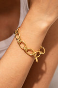Gold chunky chain bracelet with oval links and round clasp detail on wrist