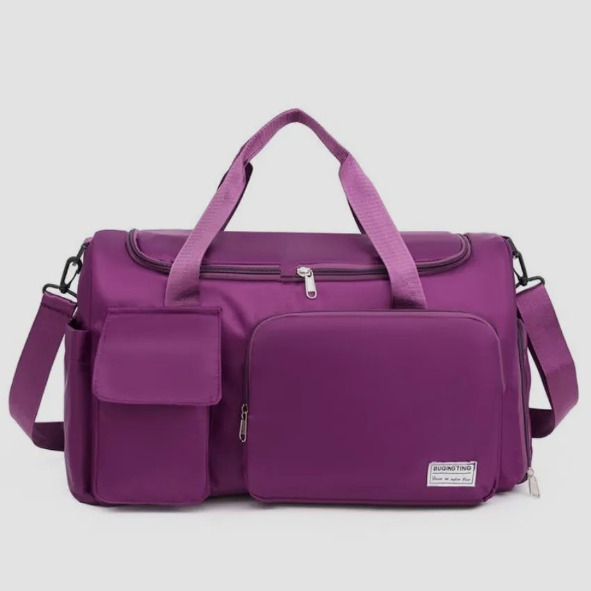 Large travel duffle bag with detachable straps, plum purple with front zip pocket.