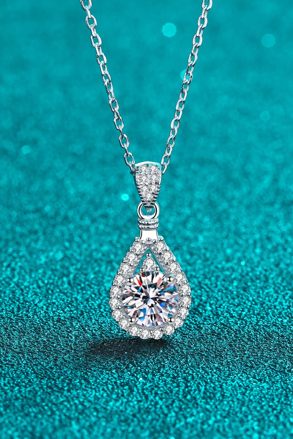 Sterling silver teardrop moissanite pendant with halo bezel on a chain