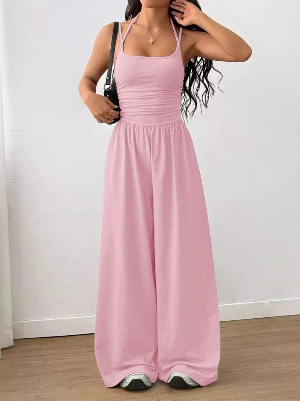 Soft pink spaghetti strap wide-leg jumpsuit with smocked waist and wide pant legs