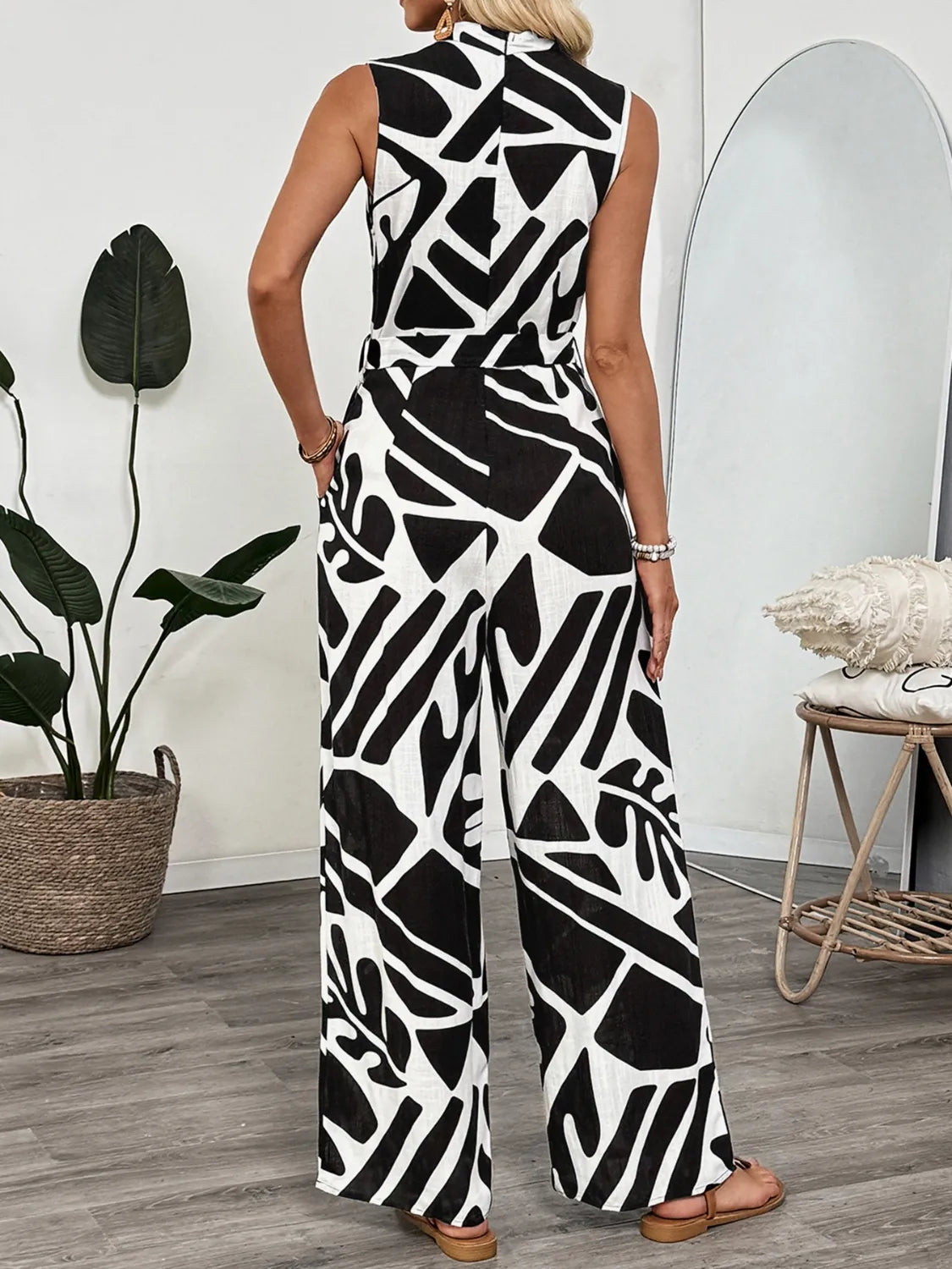 Sleeveless wide-leg jumpsuit, black-and-white abstract print, long relaxed legs.