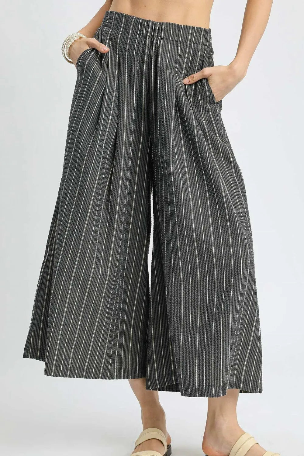 Pinstripe crop palazzo pants with elastic waistband and wide legs, dark with vertical stripes