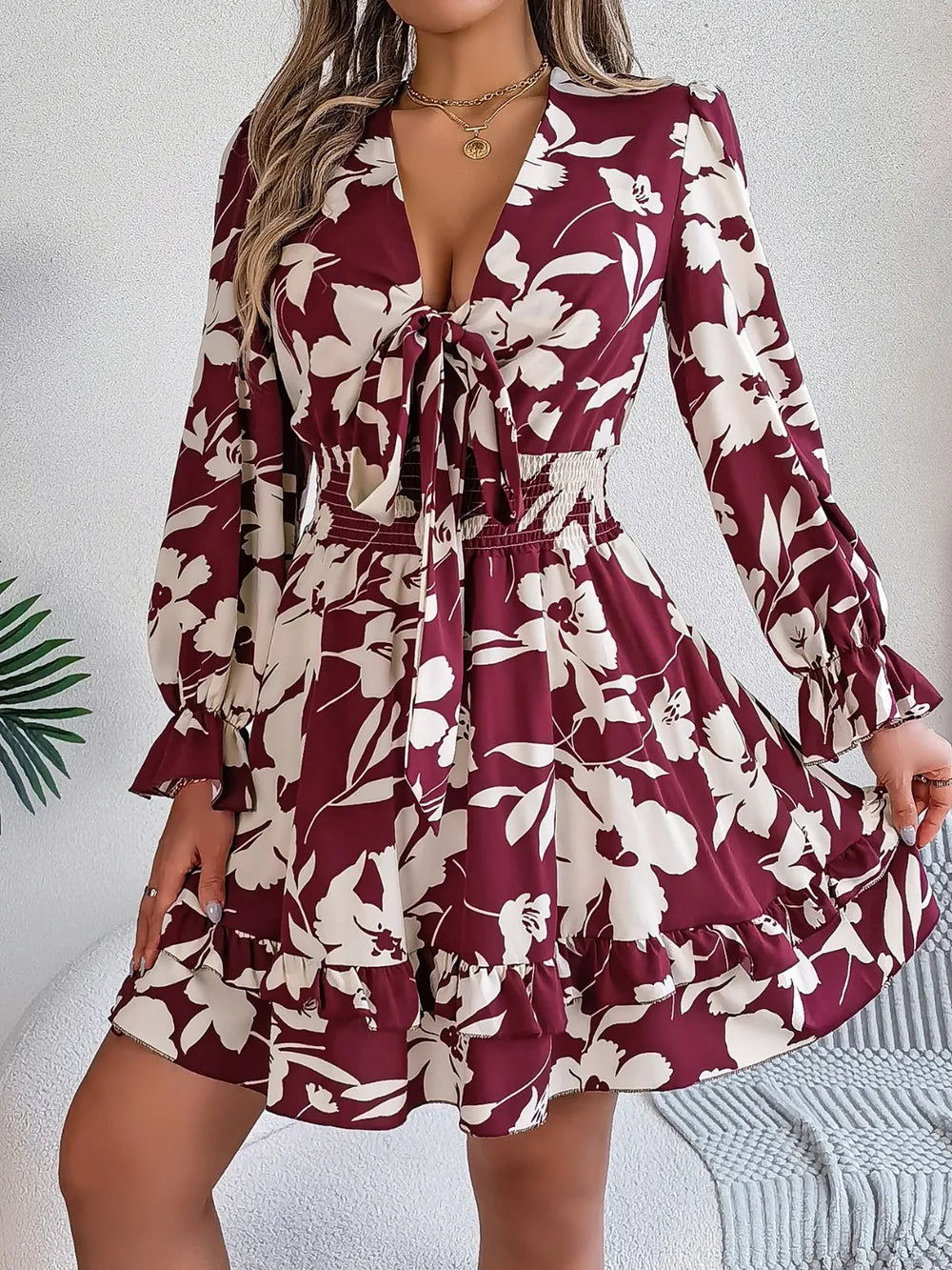 Burgundy floral long-sleeve dress with tie-front V-neck and gathered ruffle hem