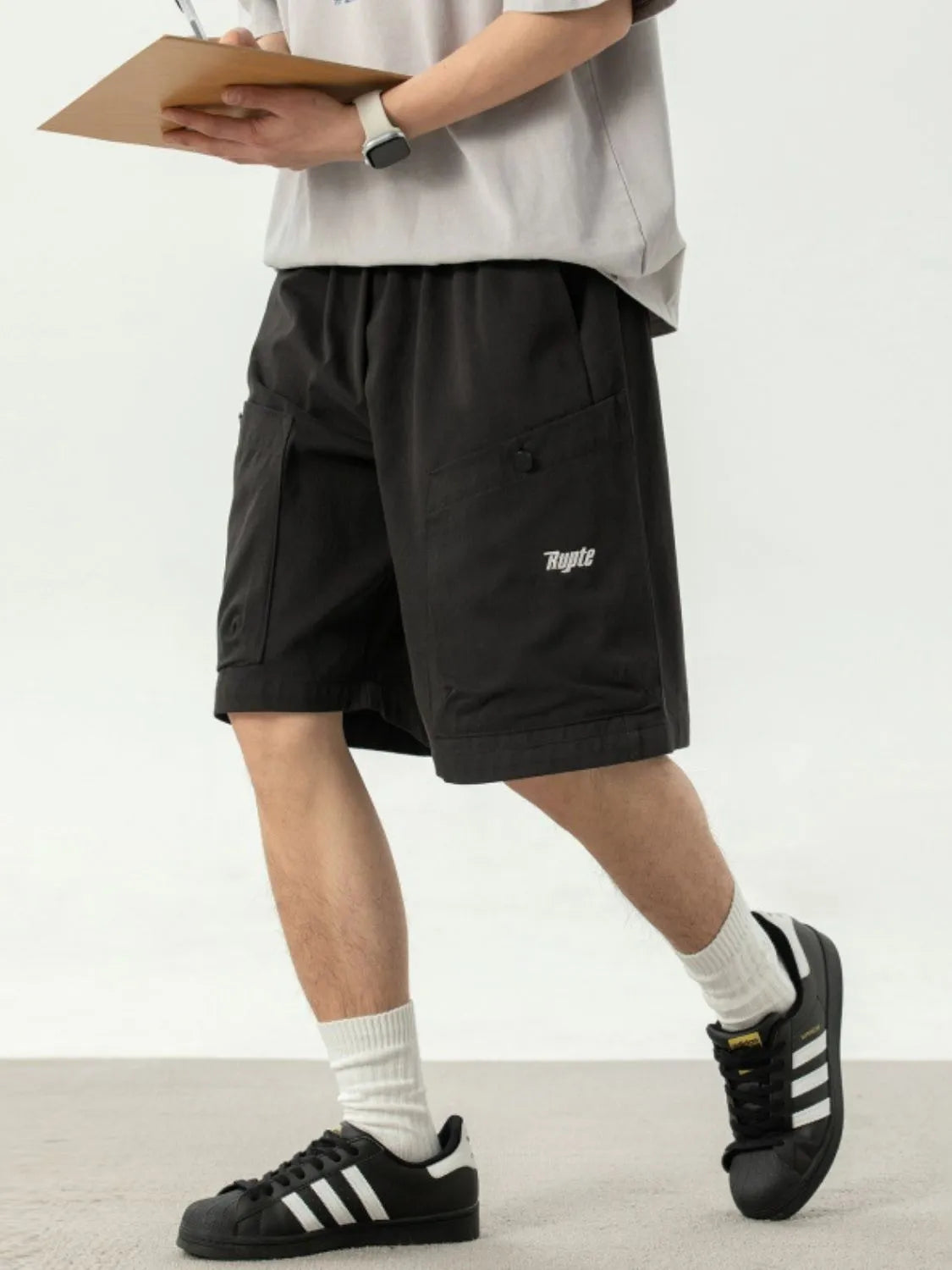 Black drawstring shorts with side pockets, elastic waist and button detail