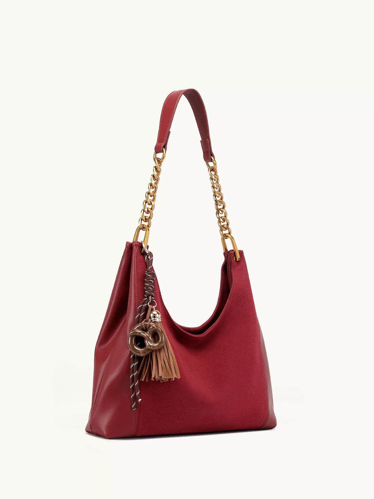 Wine red suede shoulder bag with gold chain straps and tassel, front angled view.