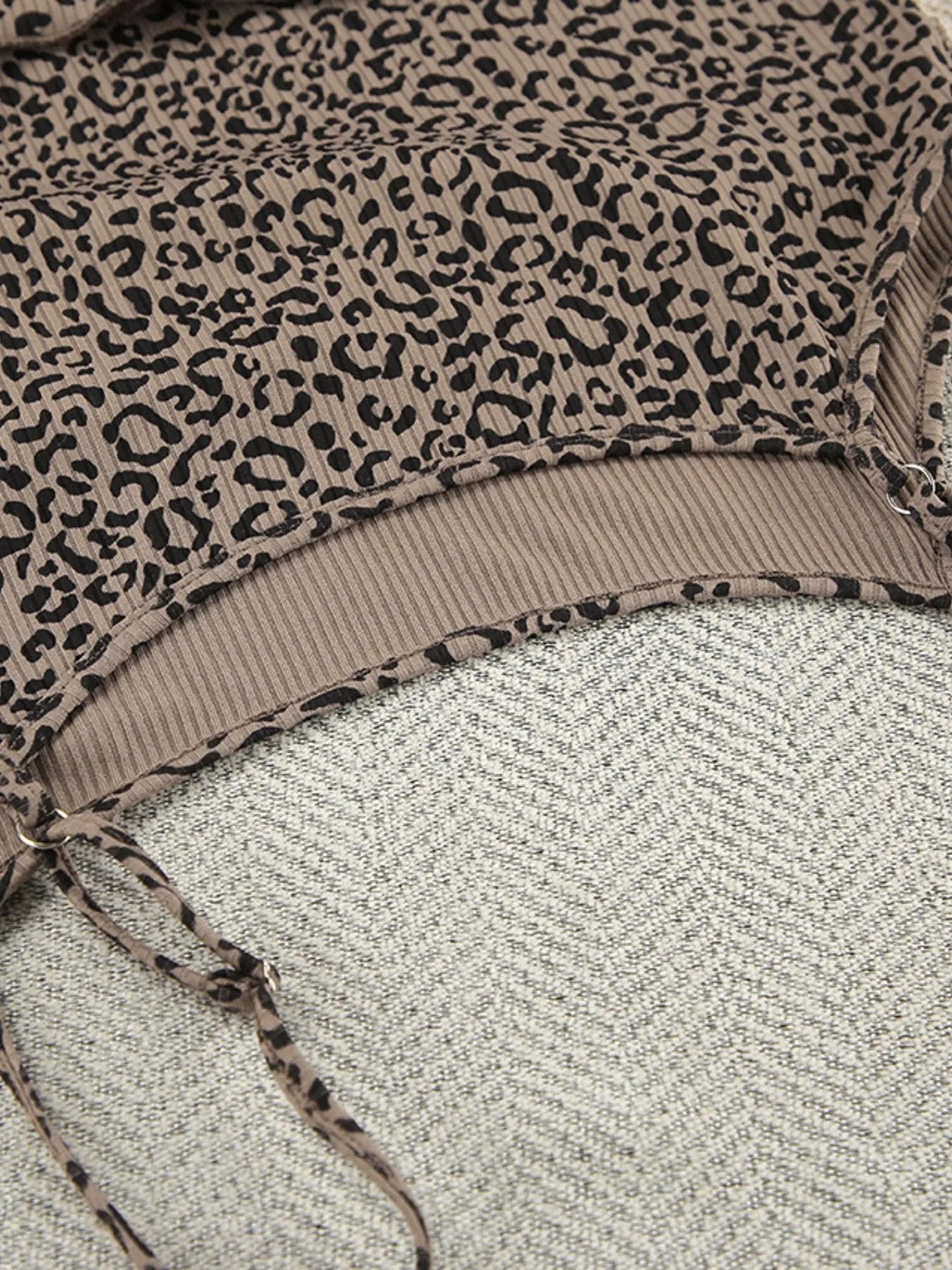 Leopard print fabric close-up with ribbed contrast trim and drawstring