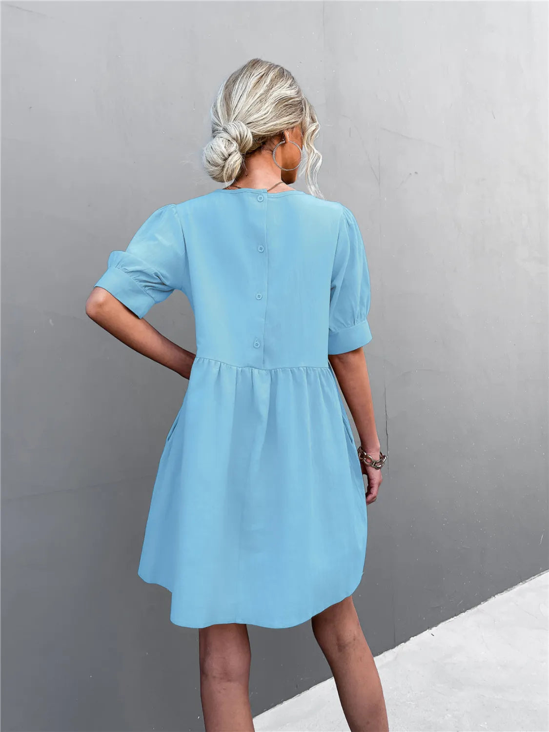Trendsi light-blue round-neck puff-sleeve mini dress; back view with buttoned placket.