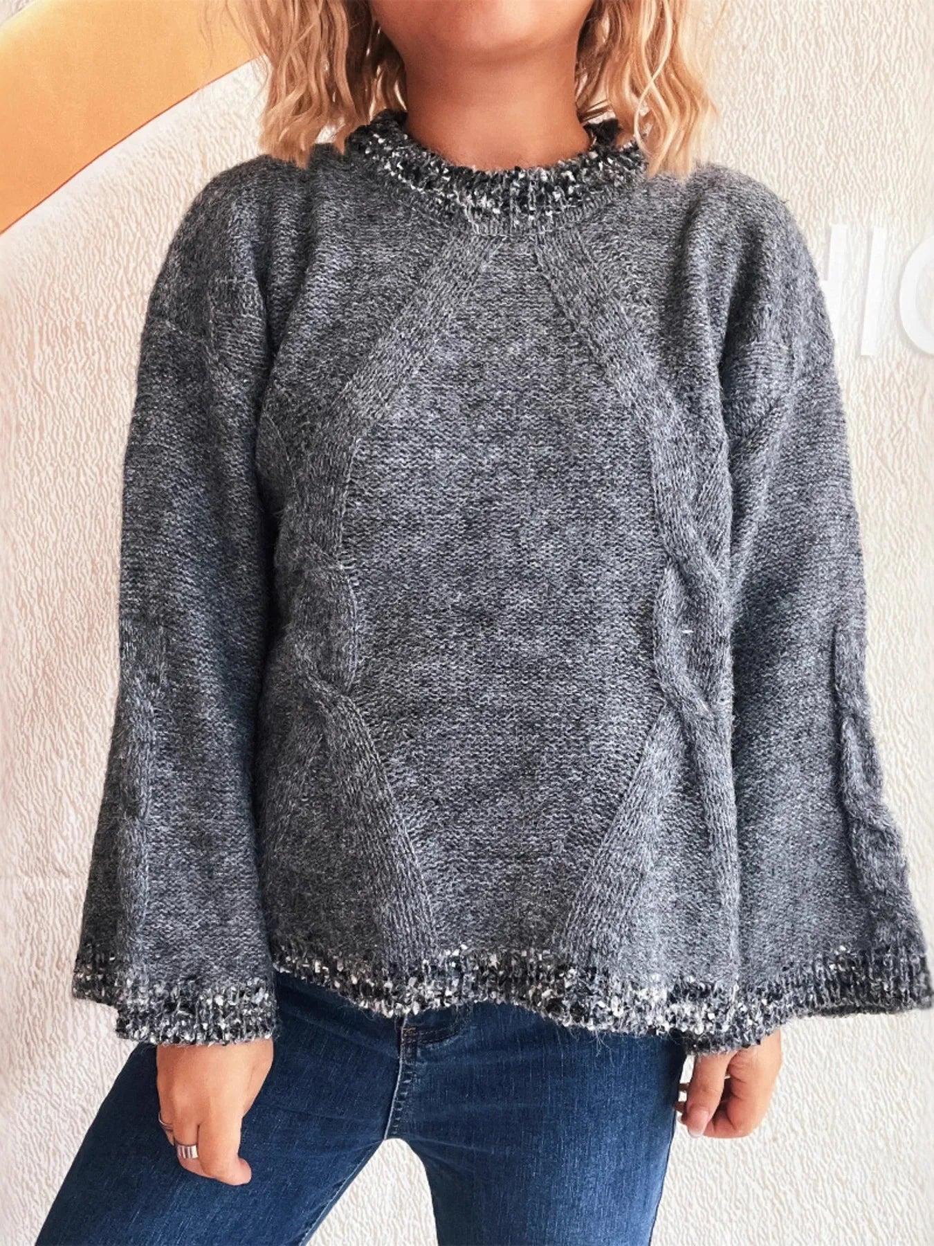 Dark gray contrast-trim round-neck sweater with decorative cuff detail and textured finish.