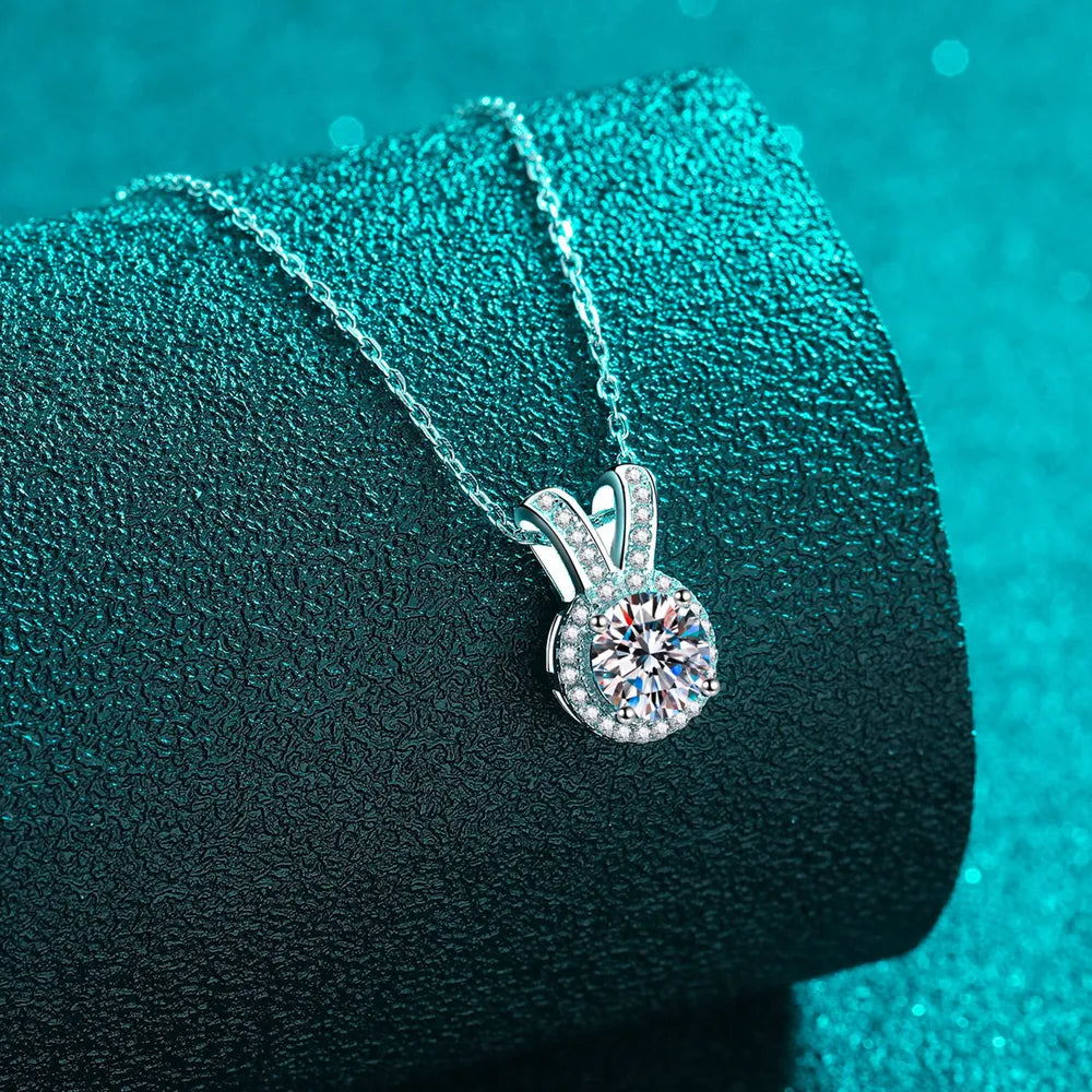 Silver rabbit-ear pendant necklace closeup: round moissanite center with pavé details
