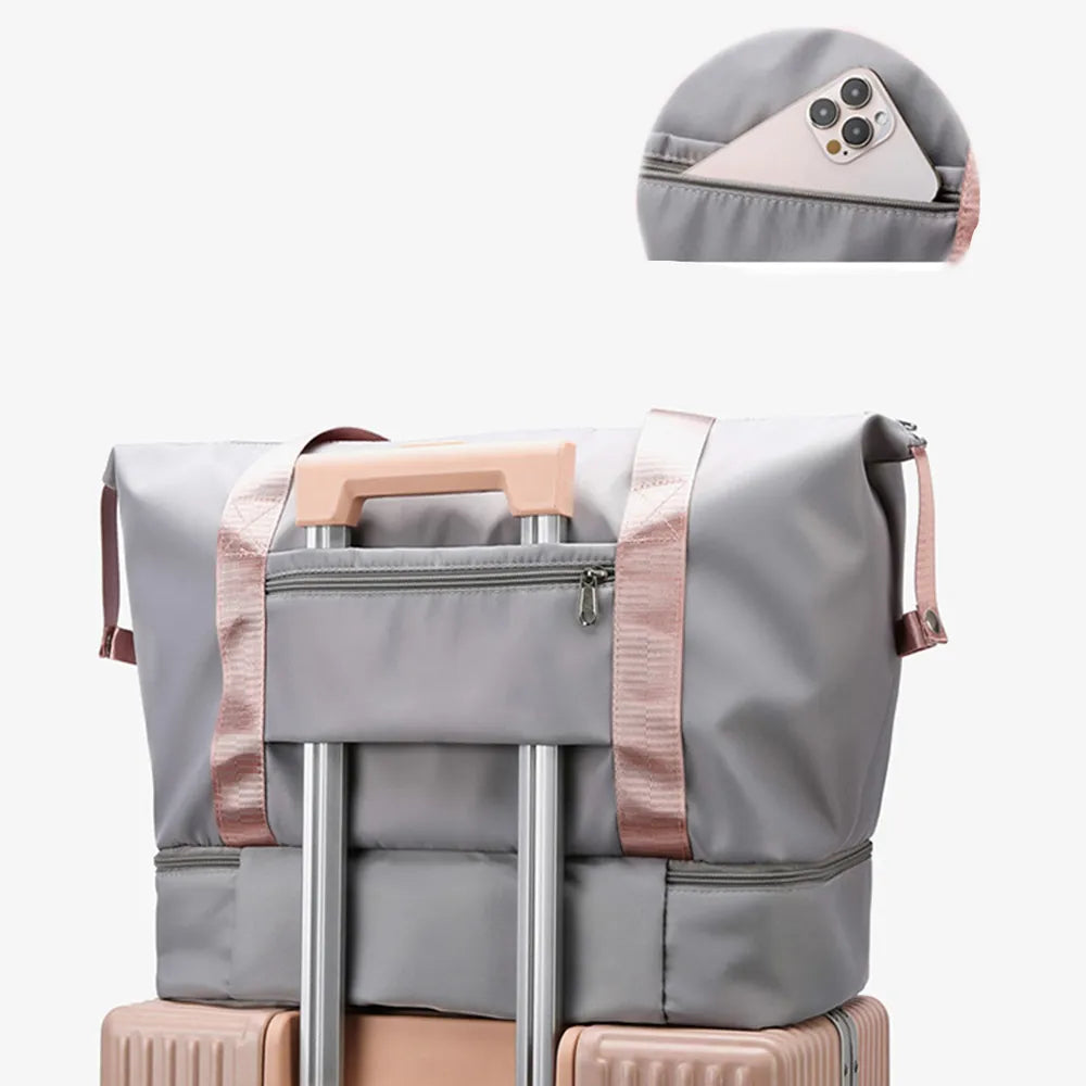 Gray nylon travel duffel bag with pink handles and open side storage