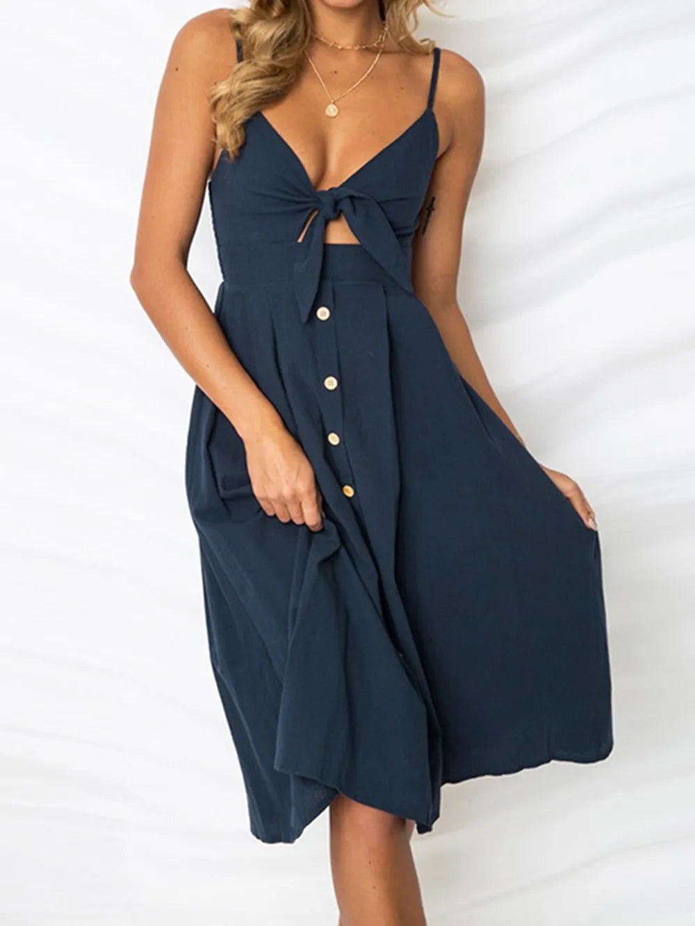 Navy cami dress with tie-front bow at bust, button placket, swirled skirt and thin straps