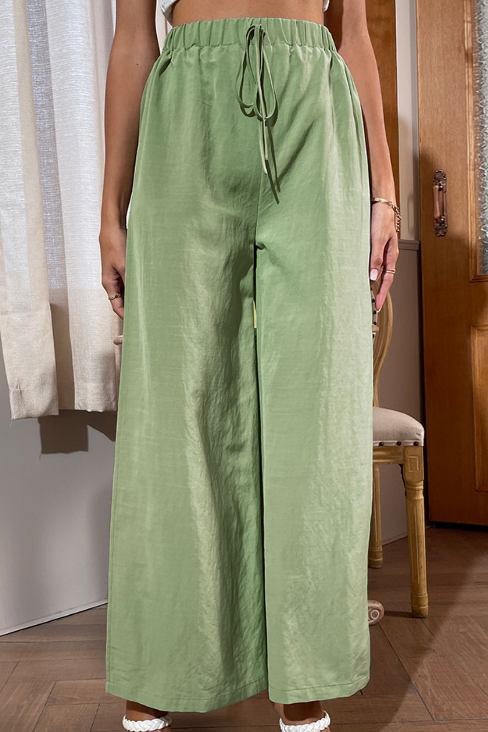 Green wide-leg pants with drawstring waist and central seam detail