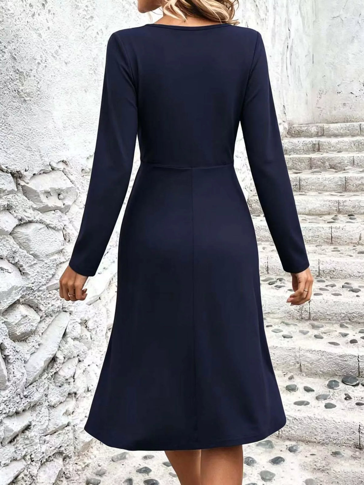 Navy blue long-sleeve midi dress with V-back and ruched waist detail.