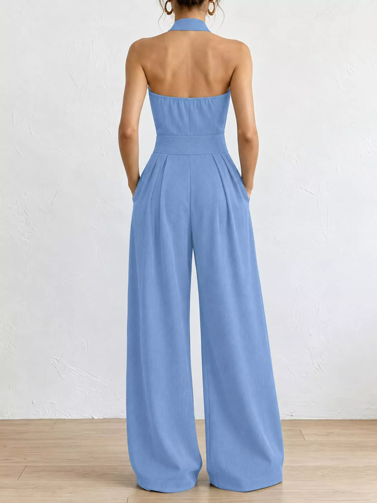 Back view of light blue halter linen jumpsuit with open back and wide legs