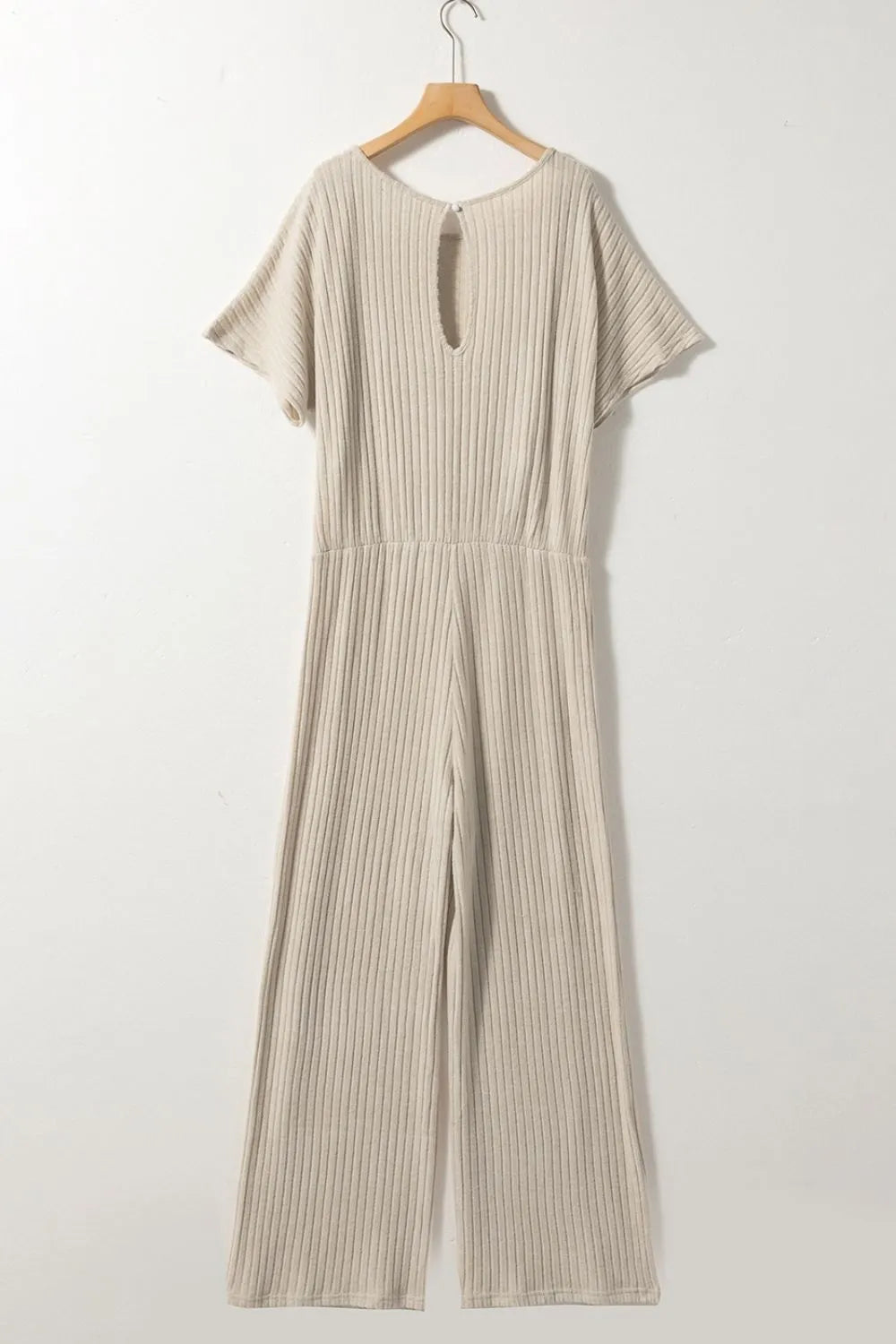 Beige ribbed knit wide-leg jumpsuit on hanger with open back keyhole