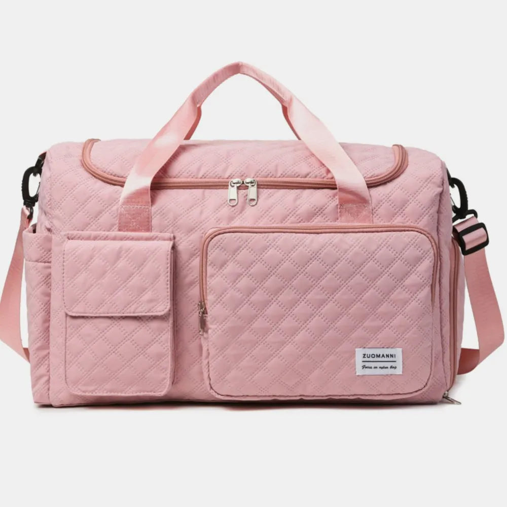 Dusty pink duffel travel bag with front zip pocket, padded handles, and side straps