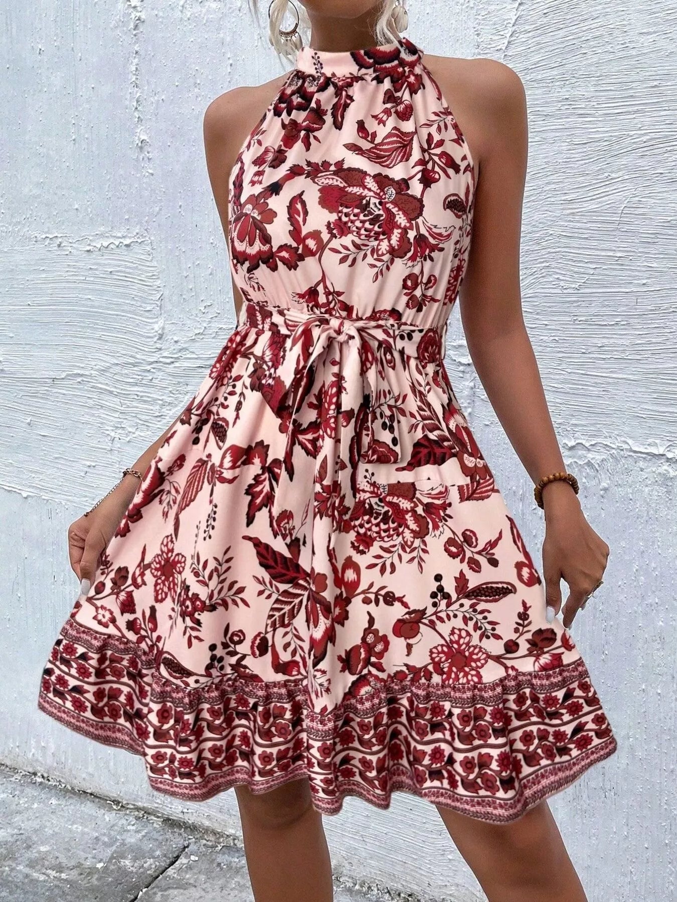 Red printed sleeveless tie waist dress with floral pattern and tiered skirt border