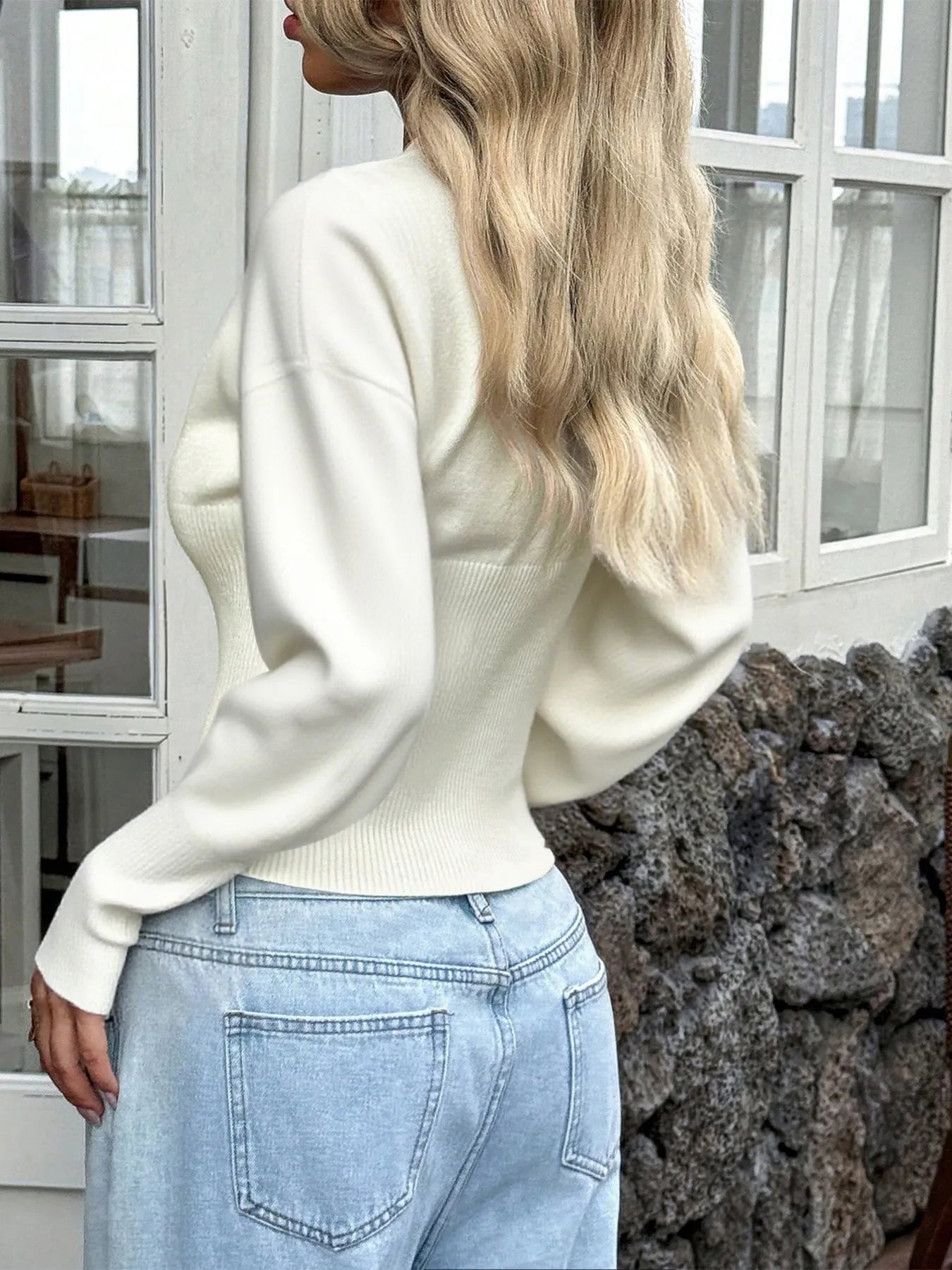 White cropped knit cardigan, back view with ribbed hem and long sleeves