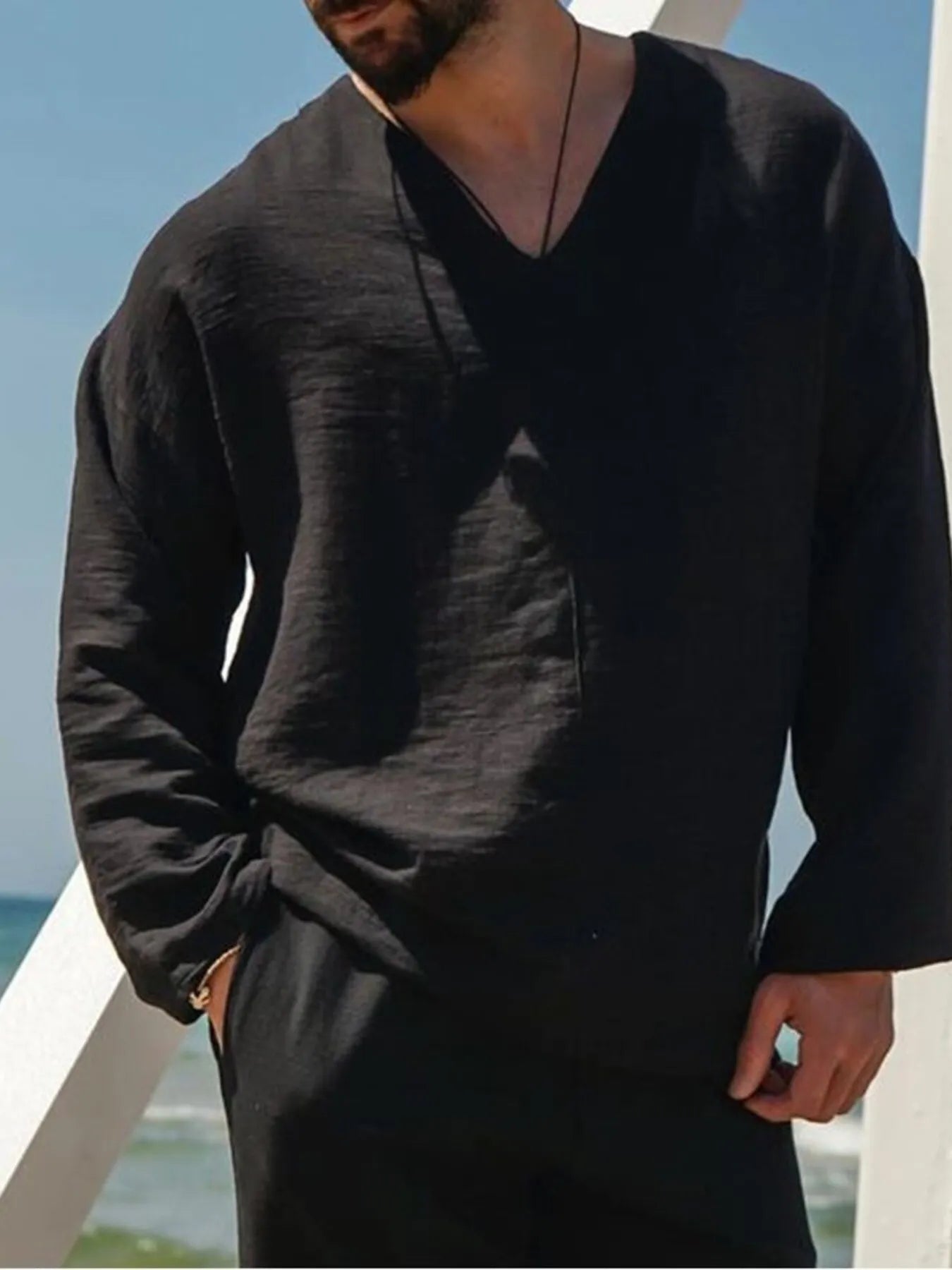 Black V-neck long sleeve top with relaxed drape and subtle textured weave
