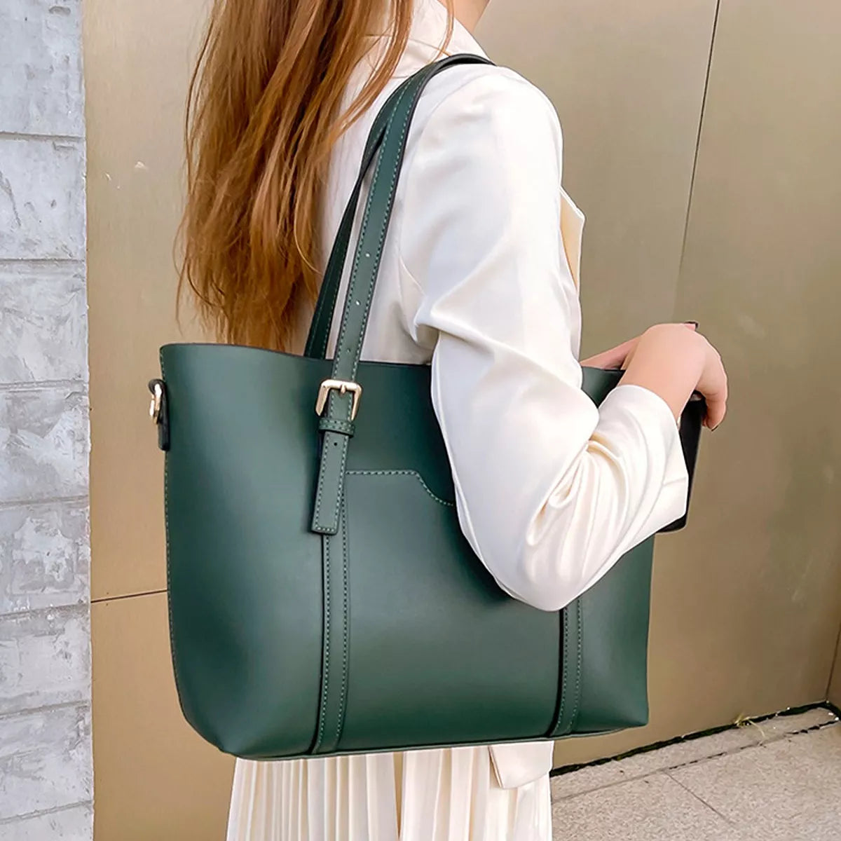 Green medium tote bag with top handle, long strap, and structured front pocket