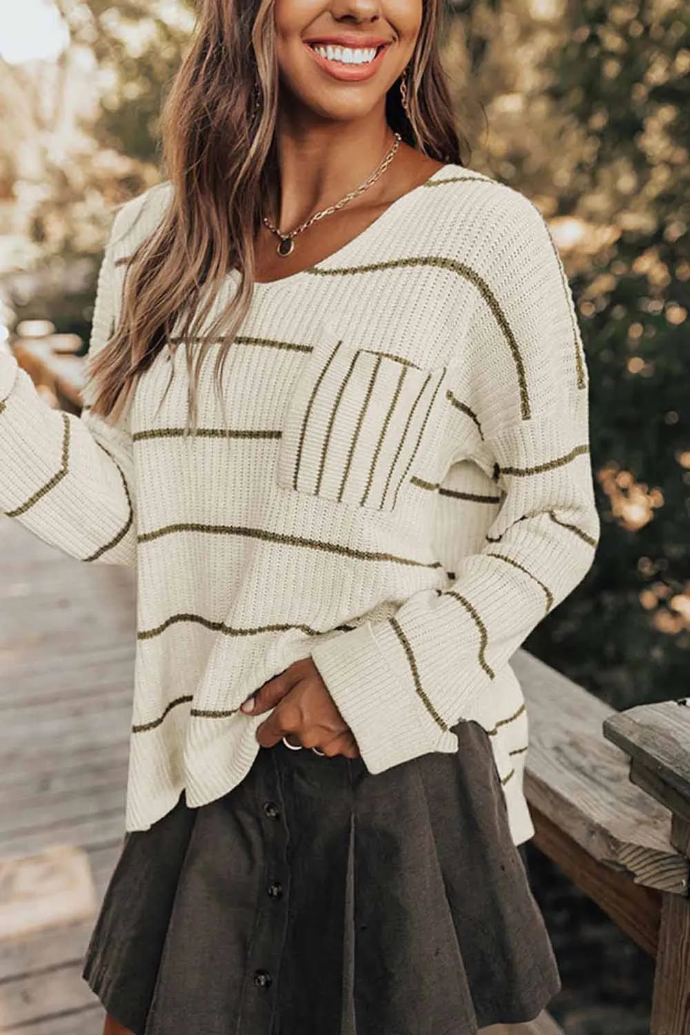 White V-neck striped sweater with pocket detail and ribbed cuffs