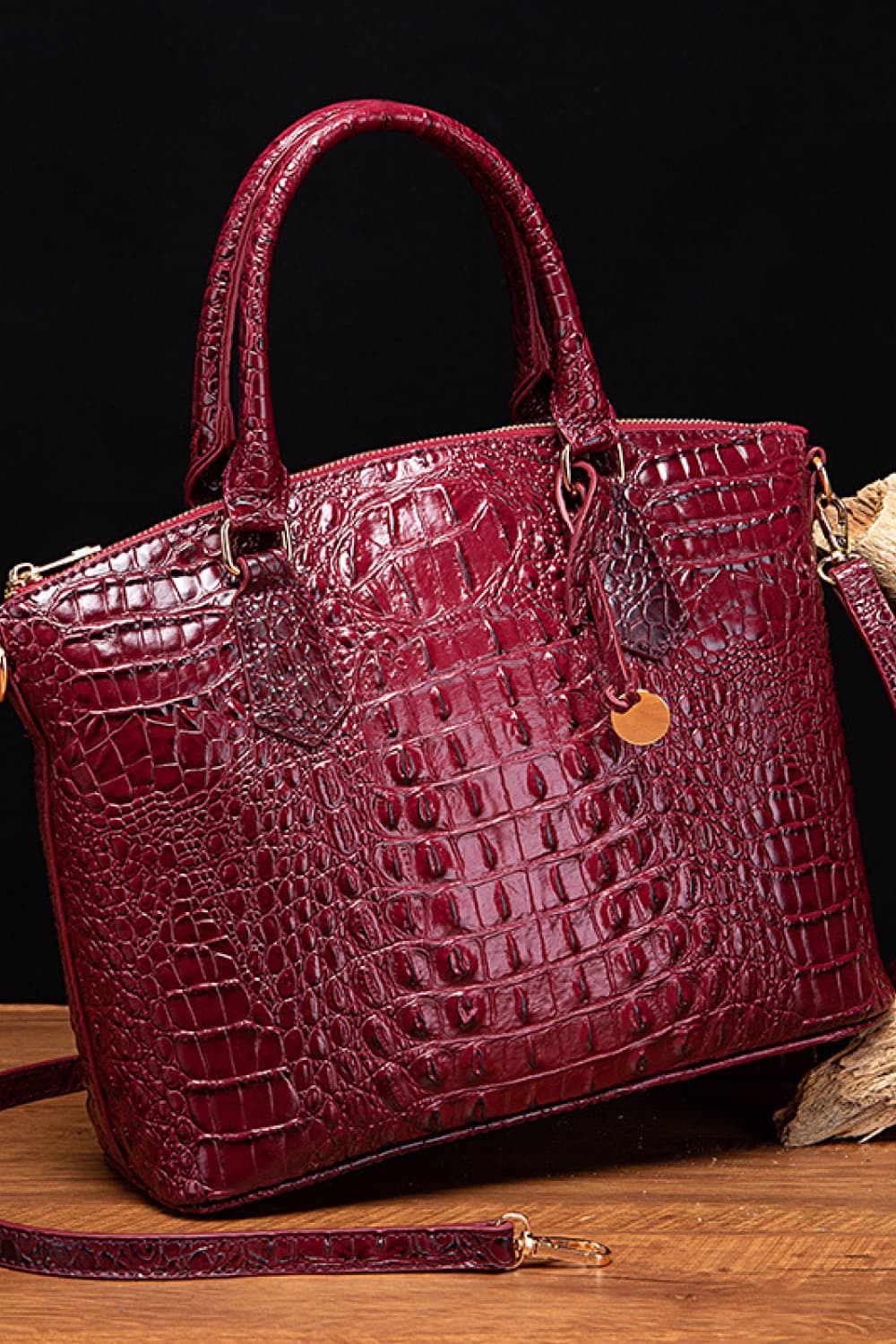 Croc-embossed vegan leather handbag in deep red with top handles and front emblem