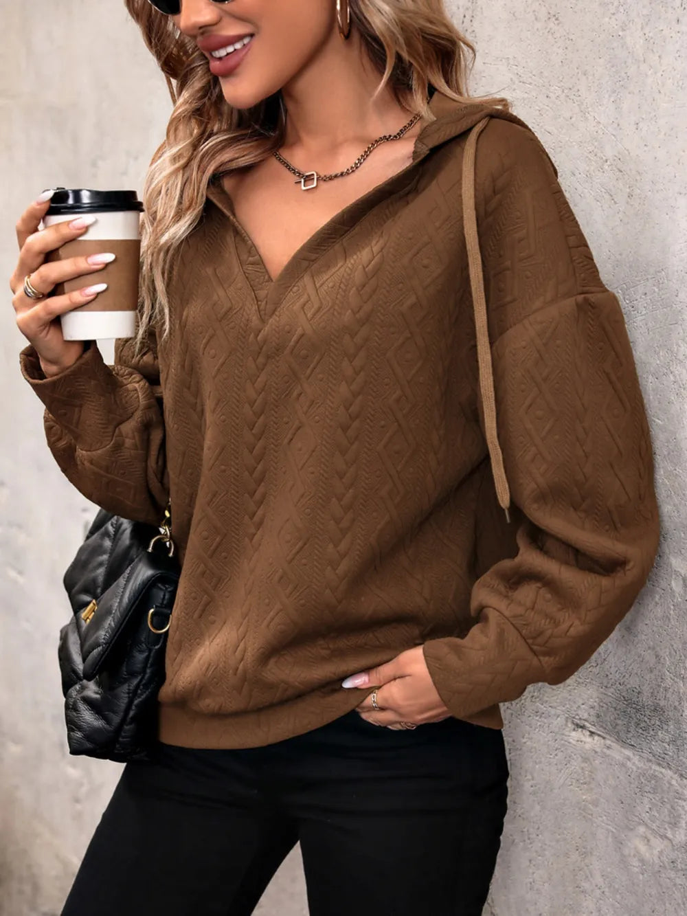 Brown drawstring hoodie with dropped shoulders, front pocket, and long sleeves