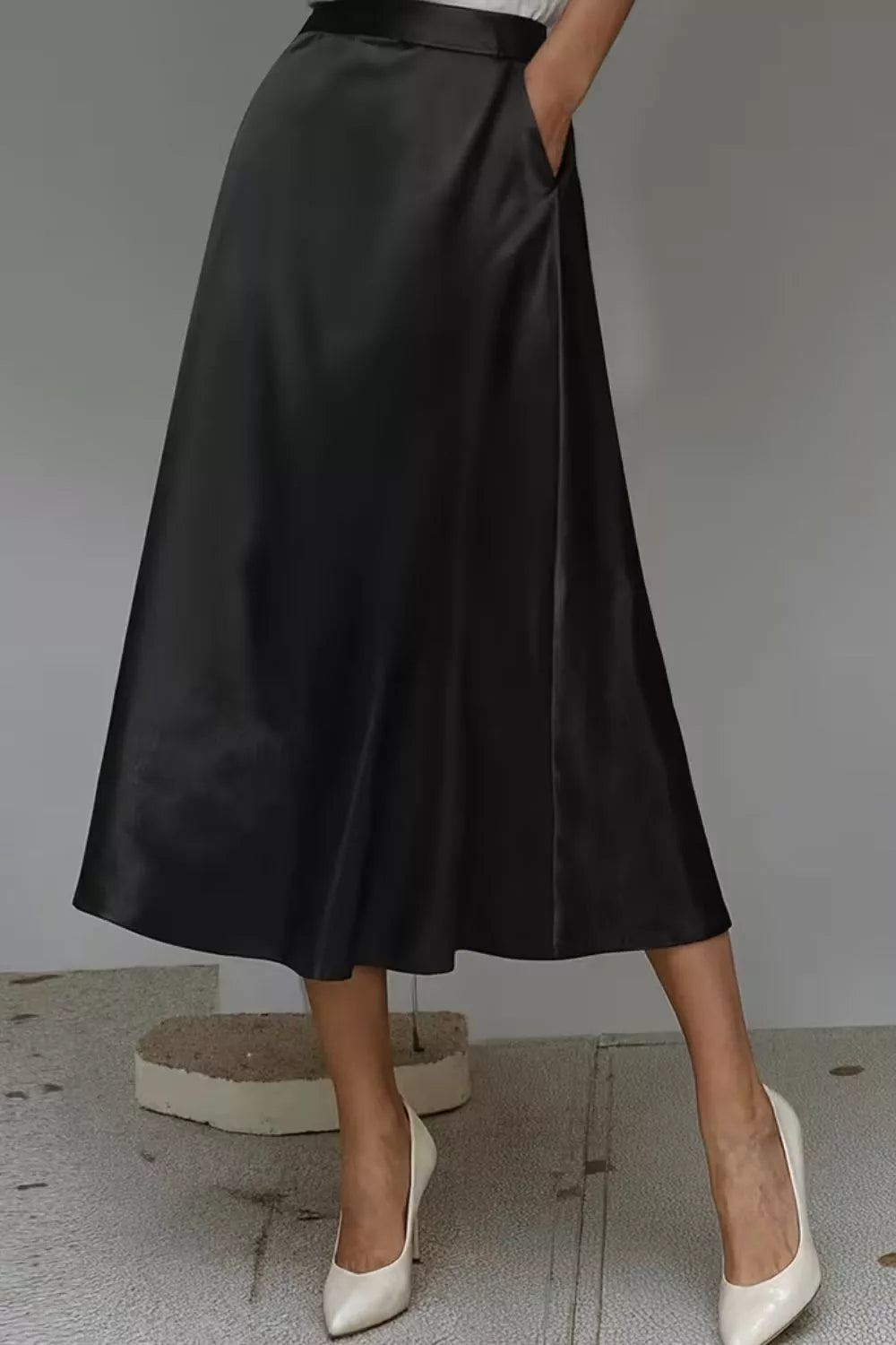 Black satin A-line midi skirt with side pockets, pleat-free front and mid-calf hem