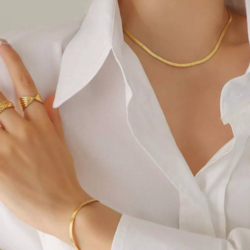 Gold-plated slim chain necklace resting at collarbone