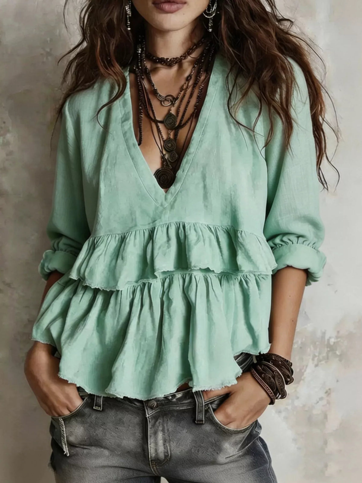 Light green ruffled V-neck blouse with tiered peplum hem and long puff sleeves