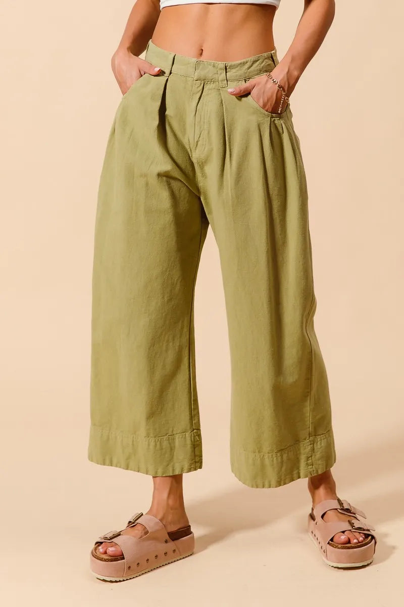 Sage green wide-leg chino pants with pleated front and side seam pockets