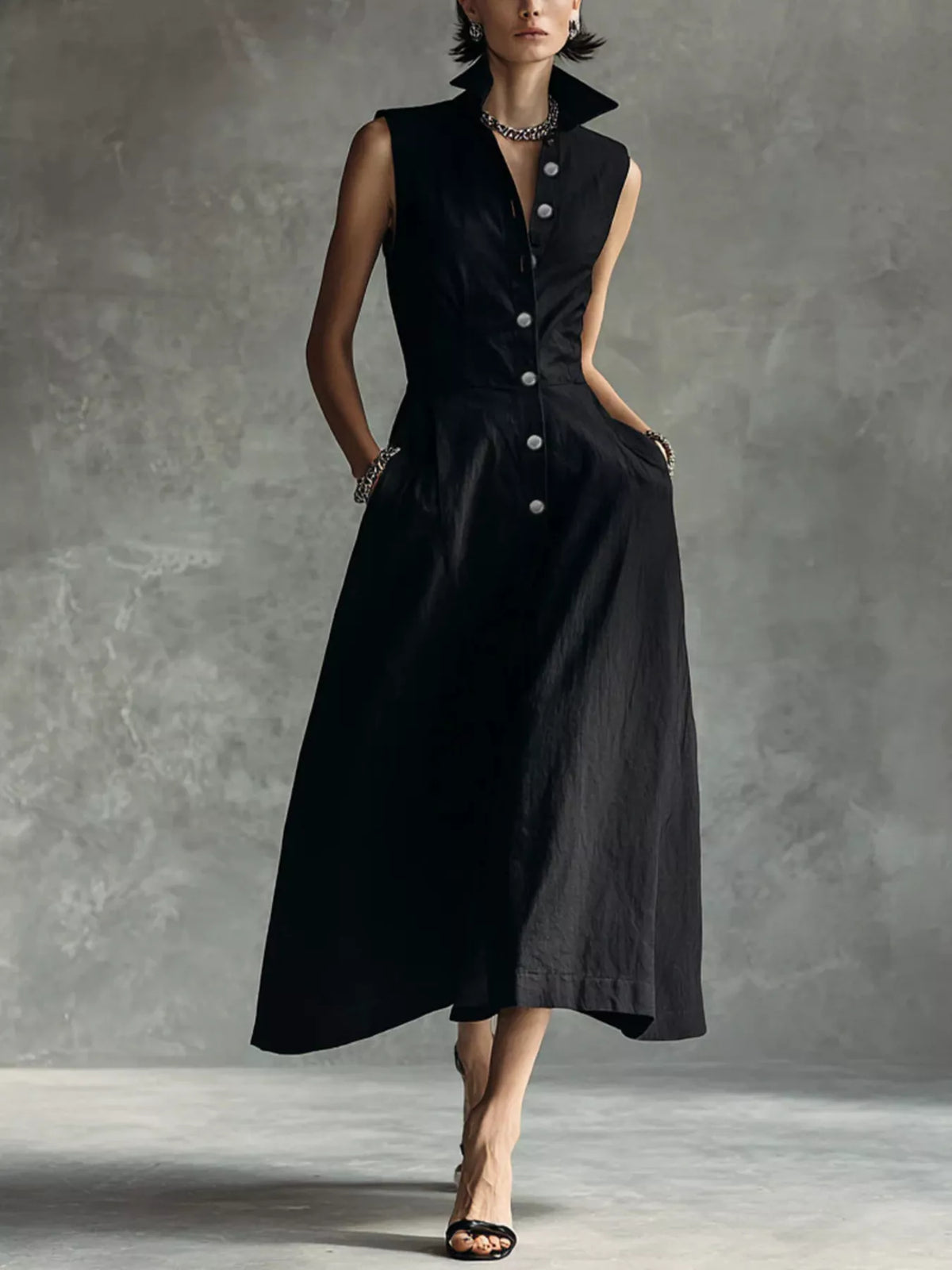 Black sleeveless midi shirt dress with pointed collar and button front, A-line skirt.